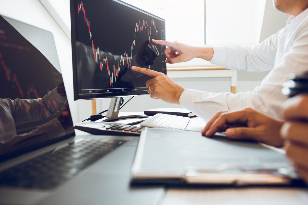 Business people talking and analysis with profit from the screen stock on the computer